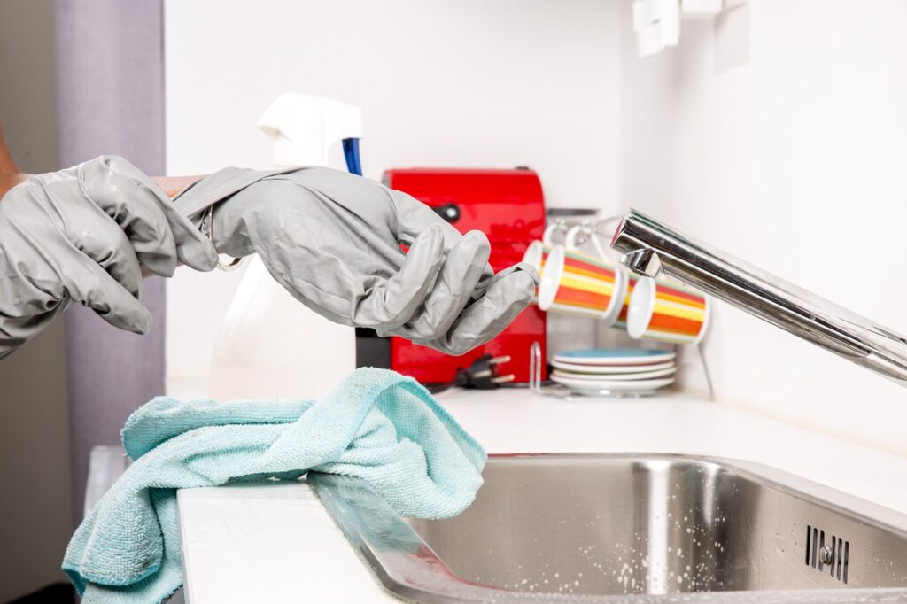Cleaner removing gloves over a spotless sink after home cleaning service in Olympia, WA